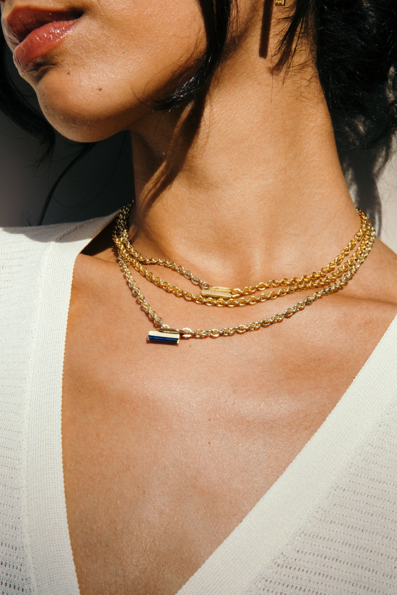 A close up of MEILI signature gemstone pillar toggle necklace worn by a women..